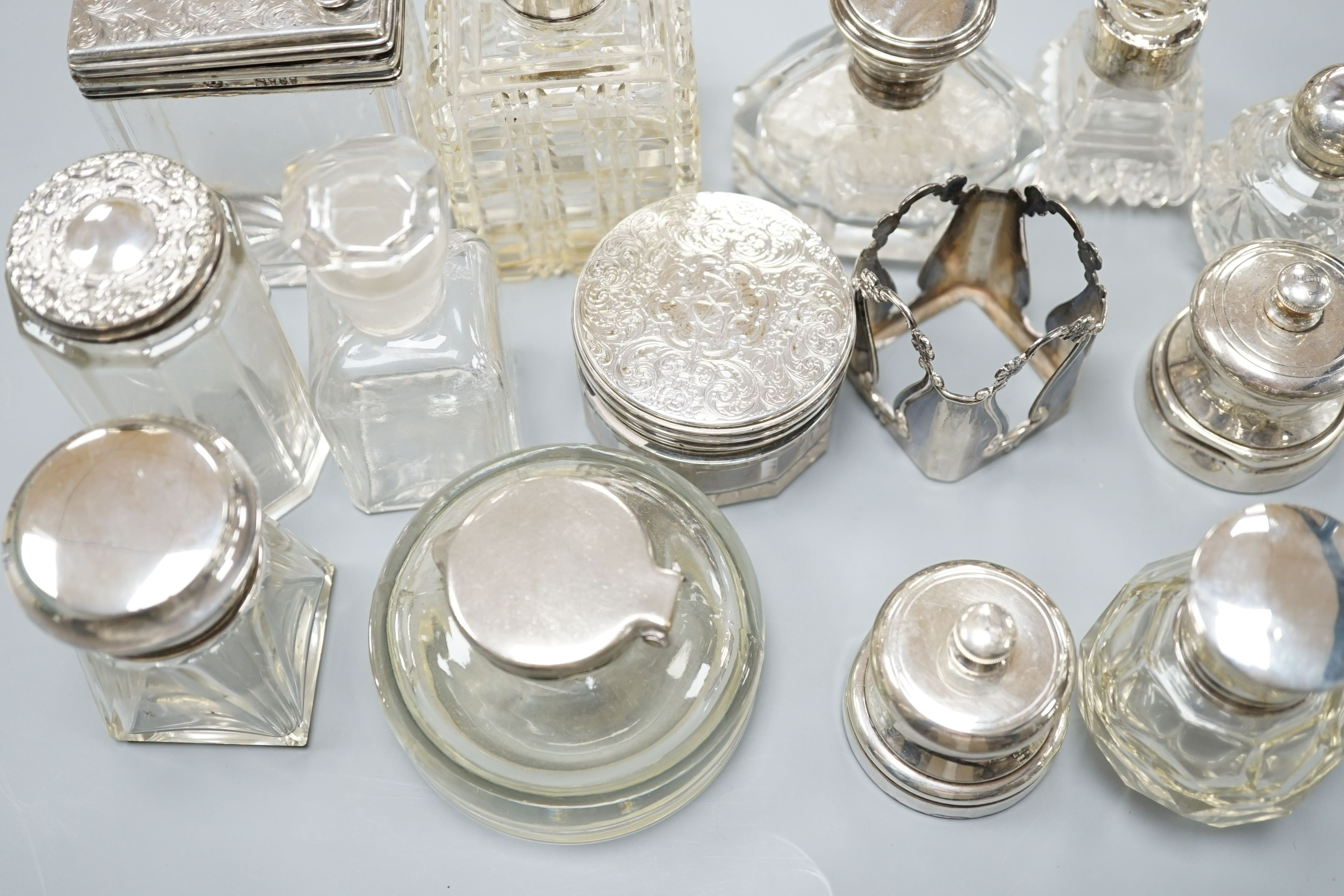 A collection of twelve assorted silver mounted glass toilet jars including Victorian, a plate mounted inkwell and a small pair of silver mounted salt and pepper mills.